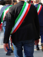 Italian mayors walking on the street with the tricolor sash of the Italian flag during the parade...