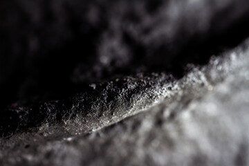 Extreme close up of painted in black handmade paper mache with a structure and rough texture.