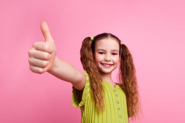 Photo portrait of pretty little girl thumb up approve wear trendy green outfit isolated on pink...