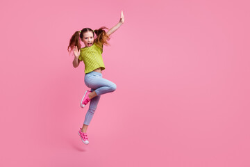 Full length photo of lovely little girl dancing have fun dressed stylish green garment isolated on pink color background