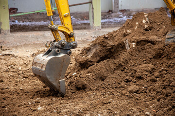 Close-up view of an excavator claw scoop digging into earth, capturing the power and precision of...