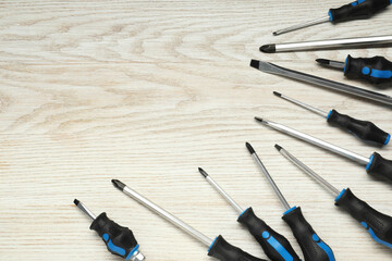 Set of screwdrivers on wooden table, above view