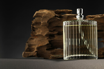 Luxury men`s perfume in bottle on grey table, space for text