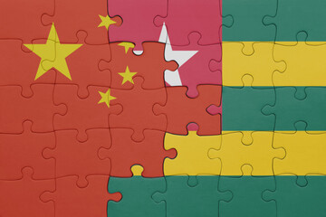 puzzle with the colourful national flag of togo and flag of china .