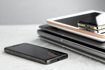 Stack of electronic devices on grey stone table, closeup