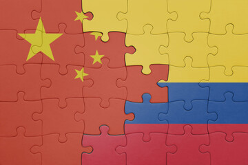 puzzle with the colourful national flag of colombia and flag of china .