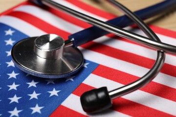 Stethoscope and USA flag on table, closeup. Health care concept