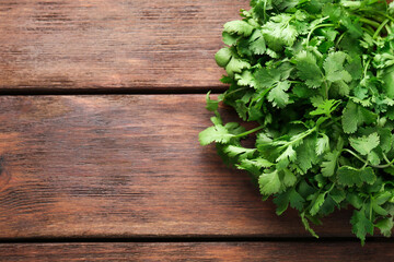Fresh coriander on wooden table, top view. Space for text