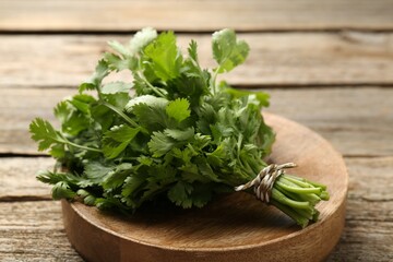 Bunch of fresh coriander on wooden table, closeup