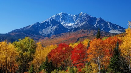 Obraz premium A majestic mountain range in autumn, with colorful foliage, clear blue skies, and a peaceful valley below, showcasing the beauty of nature in the fall season