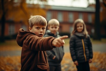 Fototapeta premium Cute little boy and girl in the autumn park pointing at camera
