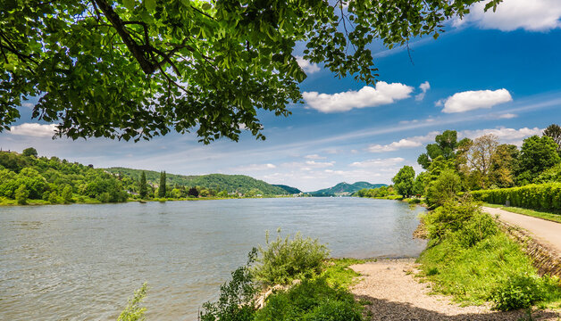 Unkel, Rheinland-Pfalz, Germany: Panoramic View of the Rhine Rhein River Promenade with Trees, Greenery and Blue Sky