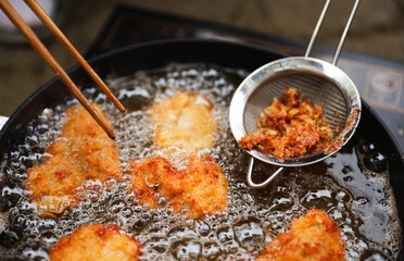 golden, crispy fried chicken pieces in bubbling oil, symbolizing indulgence and temptation