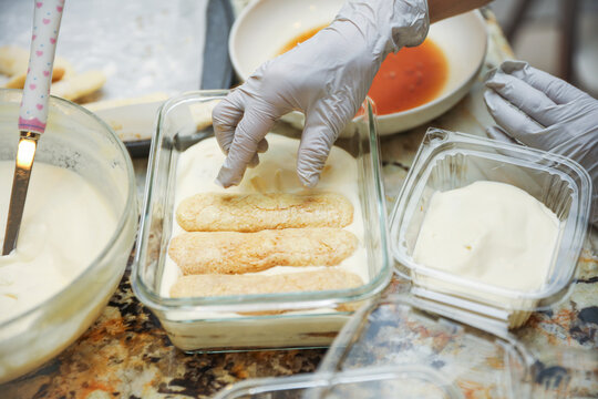 hands delicately layering ingredients to create a luscious tiramisu, showcasing the artistry of homemade desserts