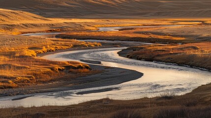The meandering path of a glacial river illuminated by golden sunlight.