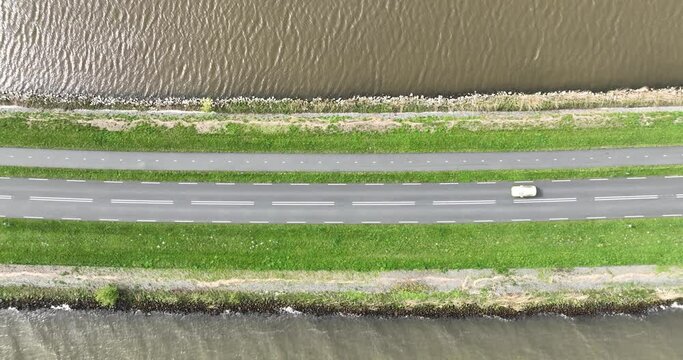 Driving road along the water in The Netherlands. Transportation by automobile.