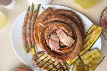 Preparing the table with various grilled dishes. A man prepares a table for guests or family.