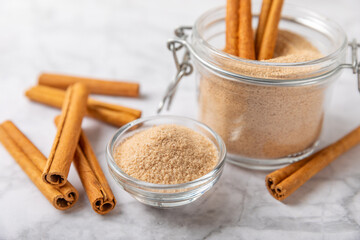 Cinnamon sugar on a texture background. Homemade cinnamon sugar in a bowl on background. Brown sugar. Spice mixture for drinks and baking. Place for text. Copy space.