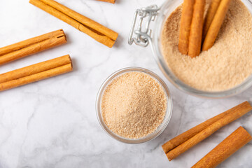 Cinnamon sugar on a texture background. Homemade cinnamon sugar in a bowl on background. Brown sugar. Spice mixture for drinks and baking. Place for text. Copy space.