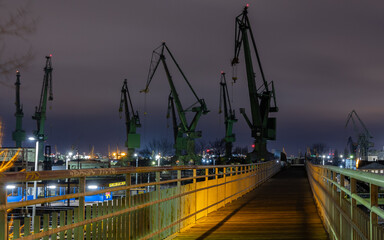 Cranes of the Gdańsk Shipyard on the Baltic coast at night © Michał Brzostowski 