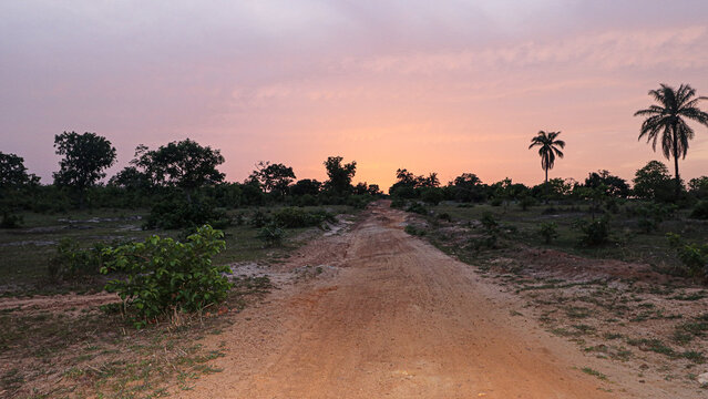 Coucher de soleil sur une route de sable rouge dans la r&eacute;gion de Sokod&eacute;, Togo, afrique de l'ouest