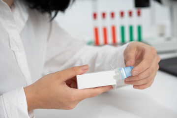 a girl medical worker takes out a medicine from a white cardboard package