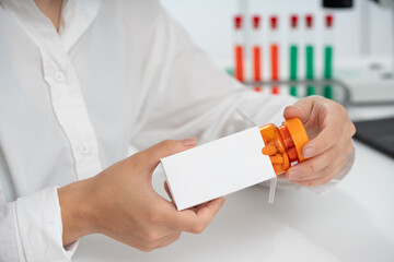 young female medical worker takes out a bottle of pills from a cardboard box