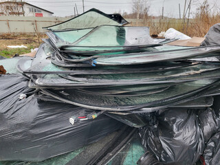 A large pile of broken auto glass in a garbage dump