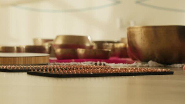 Sadhu board prepared for client against singing bowls. Special equipment serves as conduit for spiritual connection and healing during session in studio