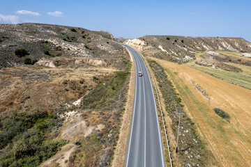 Drone aerial of countryside highway empty road crossing agriculture fields.