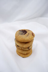 Cookie with white fabric background. Close-up a stack of cookies. White fabric backdrop texture for dessert. Butter chocolate chip cookies for the concept of baking, homemade dessert, and simplicity.