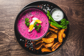 A vibrant bowl of beetroot soup, garnished with a halved boiled egg, fresh herbs, and served with a...