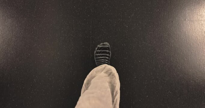 Overhead view of legs walking on marble surface