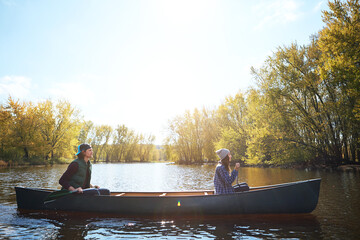 Couple, river and canoeing for forest travel at holiday camp site for relax journey, explore or...