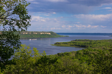 Obraz premium Mississippi River Lake Pepin In Spring - A scenic river landscape in spring with a barge traveling down river.