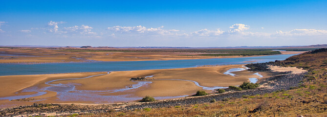 Panorama of vast mudflats with channels at the remote Butcher Inlet, at the mouth of the Harding River, near Cossack in the Pilbara region of Western Australia
