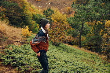 Beautiful Young Woman in Autumn Fashion Walking Along a Forest Trail in the Fall Season Beauty of...