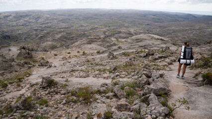 Outdoor activities. View of a woman hiking along a foot trail high in the rocky mountains.	