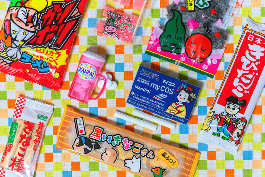 tokyo, japan - fev 17 2024: Top view photo of various Japanese dagashi kids confectioneries featuring cocoa cigarettes and a beer mug,kinako sticks, preserved plums, kombu kelp or spicy garlic ramens.