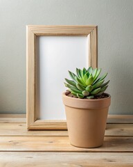 Succulent plant and empty frame on wooden surface