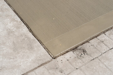 freshly poured section of concrete drying on sidewalk