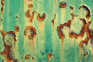Imagen horizontal de un metal pintado de verde oxidado y viejo desgastado por el tiempo con huecos...