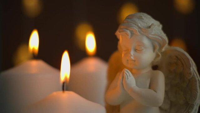 angel in prayer, surrounded by burning candles. A moment of solace and reflection during times of need. Faith and spirituality. The sacred flame. 