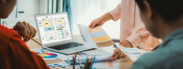 Cropped image of interior designer team discuss the material color while laptop displayed website...