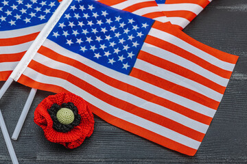 Memory Day concept. United States of America flags and handmade crochet poppy flower