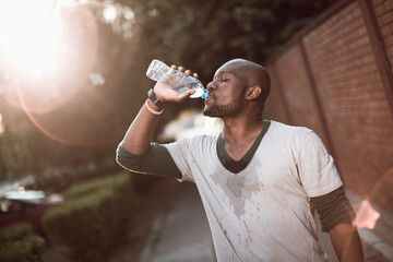 African American man drinking water after outdoor exercise session
