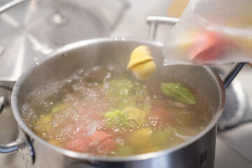 In a pot, colorful dumplings are being boiled. Preparing lunch or dinner
