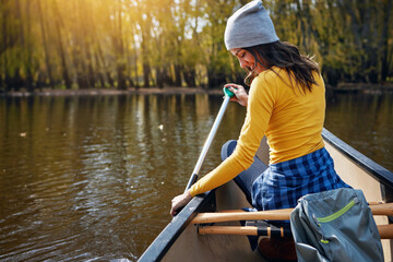 Woman, back and canoeing in nature on river, wellness hobby and backpack for supplies with paddle...