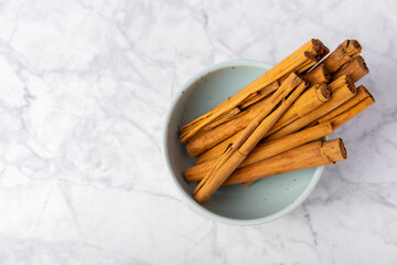Ceylon cinnamon.Cinnamon sticks on a textured wooden background. Cinnamon roll and powder. Spicy spice for baking, desserts and drinks. Fragrant ground cinnamon. Close-up. Place for text. copy space