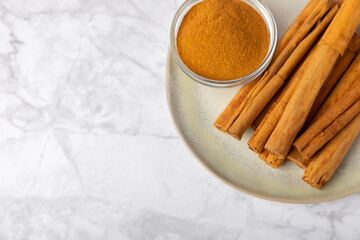 Ceylon cinnamon.Cinnamon sticks on a textured wooden background. Cinnamon roll and powder. Spicy spice for baking, desserts and drinks. Fragrant ground cinnamon. Close-up. Place for text. copy space
